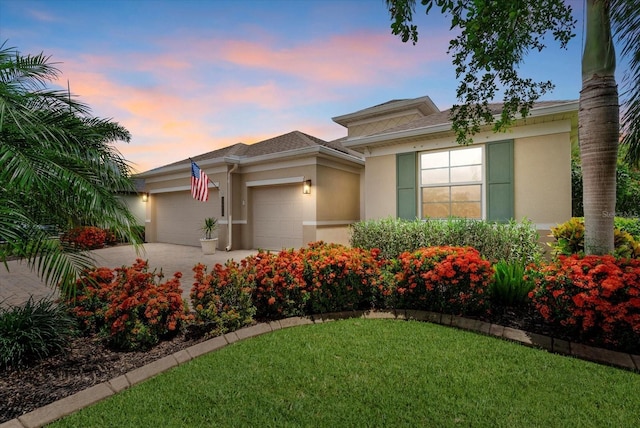 12215 Goldenrod Ave, Bradenton, FL 34212 - view of front facade featuring stucco siding, an attached garage, driveway, and a front lawn