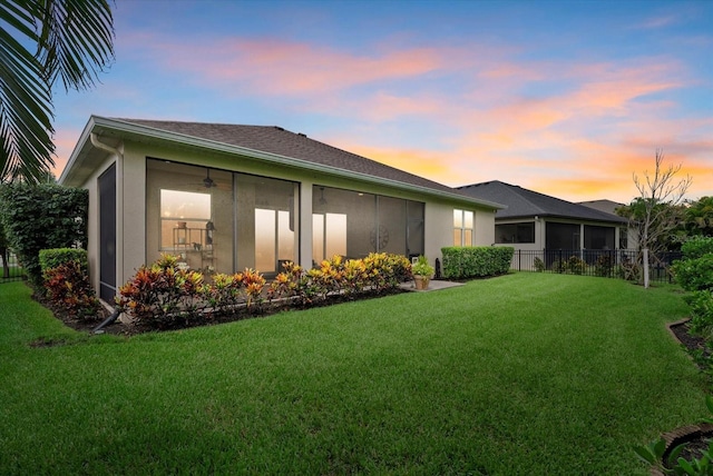 12215 Goldenrod Ave, Bradenton, FL 34212 - back of house at dusk with a sunroom and stucco siding