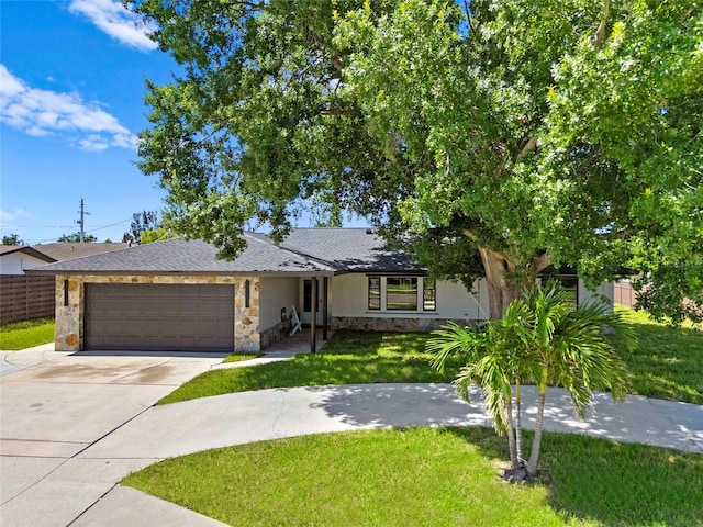 3136 Webber St, Sarasota, FL 34239 - view of front of house featuring stone siding, an attached garage, concrete driveway, and stucco siding