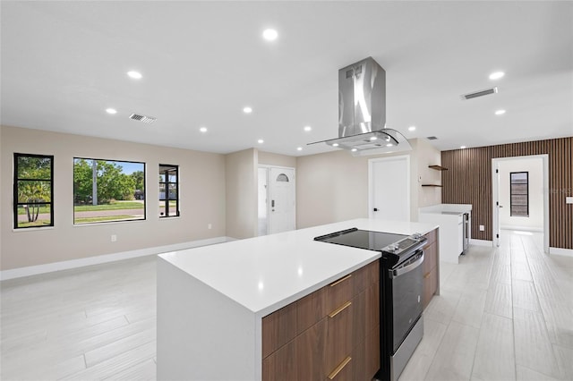 3136 Webber St, Sarasota, FL 34239 - kitchen with stainless steel range with electric stovetop, island exhaust hood, modern cabinets, a spacious island, and light countertops