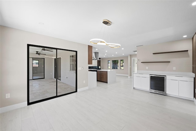 3136 Webber St, Sarasota, FL 34239 - unfurnished living room featuring beverage cooler, a chandelier, light wood-style floors, recessed lighting, and a ceiling fan