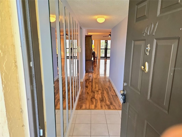 515 30th Ave W Unit H401, Bradenton, FL 34205 - hallway with a textured ceiling and light tile patterned floors