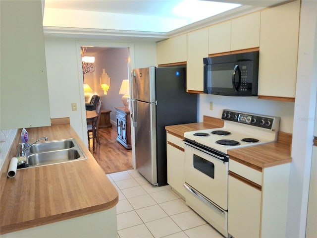 515 30th Ave W Unit H401, Bradenton, FL 34205 - kitchen featuring white range with electric stovetop, black microwave, wood counters, a chandelier, and freestanding refrigerator