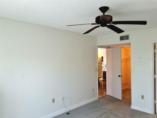 515 30th Ave W Unit H401, Bradenton, FL 34205 - unfurnished bedroom featuring carpet flooring, a closet, a spacious closet, freestanding refrigerator, and a textured ceiling