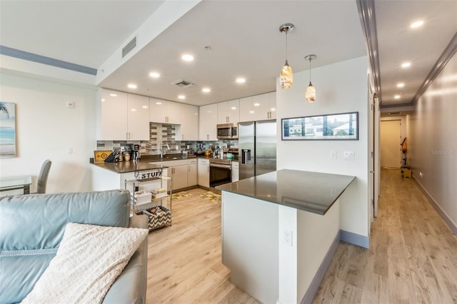 1709 N Tamiami Trl Unit A313, Sarasota, FL 34234 - kitchen featuring appliances with stainless steel finishes, dark countertops, white cabinets, light wood-style flooring, and recessed lighting