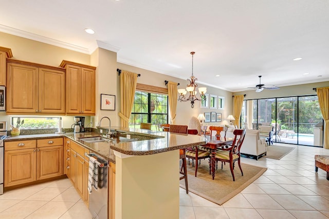 7314 Wexford Ct, Lakewood Ranch, FL 34202 - kitchen with stainless steel appliances, light tile patterned flooring, a peninsula, open floor plan, and dark stone countertops