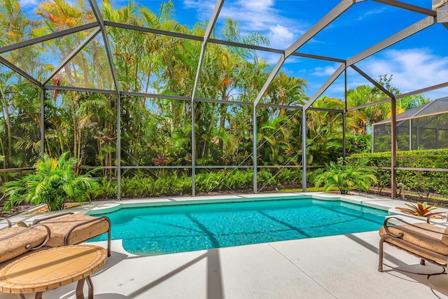 7314 Wexford Ct, Lakewood Ranch, FL 34202 - outdoor pool with a patio area, view of wooded area, and glass enclosure