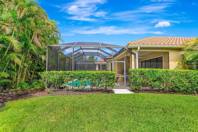 7314 Wexford Ct, Lakewood Ranch, FL 34202 - back of property featuring a tiled roof, a yard, stucco siding, and glass enclosure