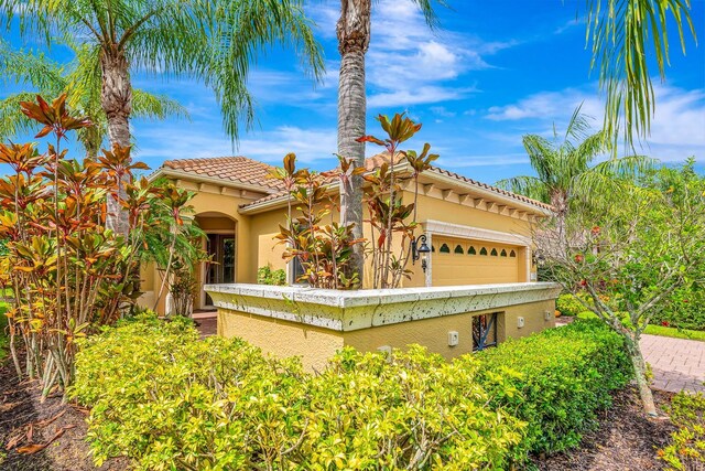 7314 Wexford Ct, Lakewood Ranch, FL 34202 - mediterranean / spanish house featuring stucco siding, a tiled roof, and an attached garage