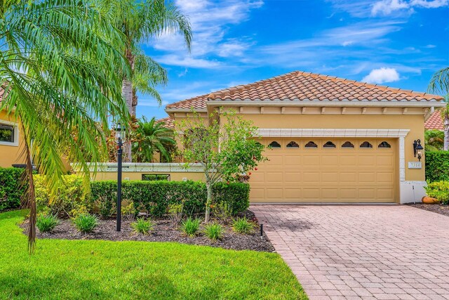 7314 Wexford Ct, Lakewood Ranch, FL 34202 - view of front facade with decorative driveway, a front yard, stucco siding, a garage, and a tiled roof