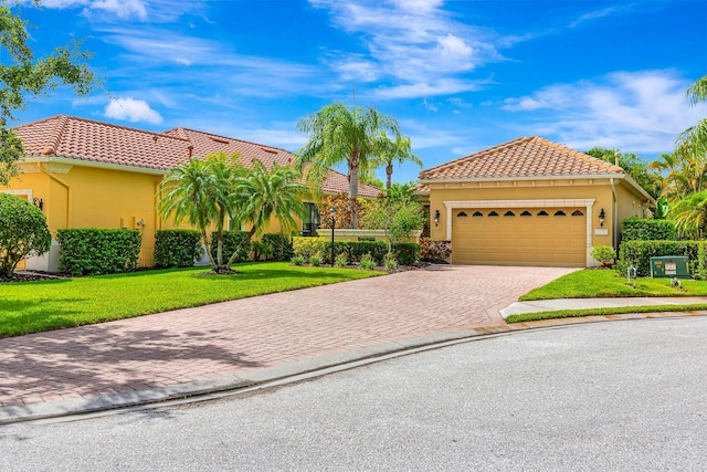 7314 Wexford Ct, Lakewood Ranch, FL 34202 - mediterranean / spanish home with decorative driveway, a front lawn, stucco siding, a tiled roof, and a garage