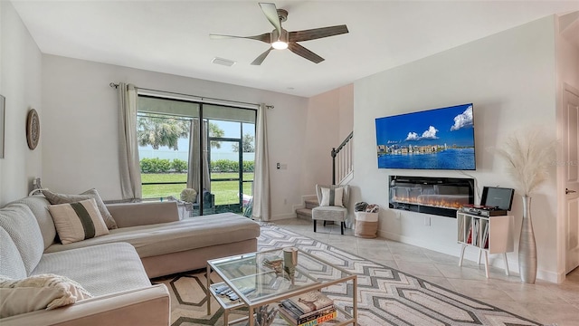 15160 Lyla Ter, Bradenton, FL 34211 - tiled living room featuring a glass covered fireplace, a ceiling fan, and stairs