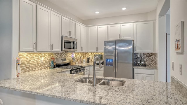 15160 Lyla Ter, Bradenton, FL 34211 - kitchen with stainless steel appliances, light stone counters, backsplash, white cabinets, and recessed lighting
