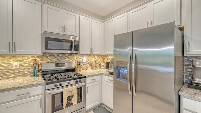 15160 Lyla Ter, Bradenton, FL 34211 - kitchen featuring appliances with stainless steel finishes, decorative backsplash, white cabinetry, and light stone counters