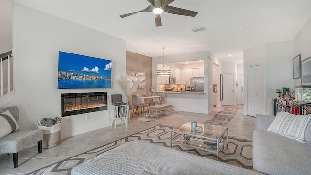 15160 Lyla Ter, Bradenton, FL 34211 - living area with a ceiling fan, a glass covered fireplace, and light tile patterned flooring