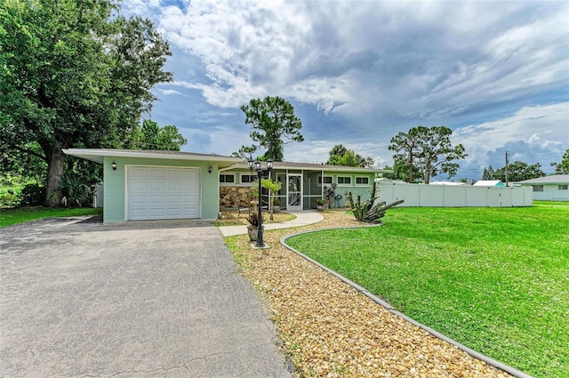 557 Reading St NW, Port Charlotte, FL 33952 - view of front of house with an attached garage, driveway, and stone siding