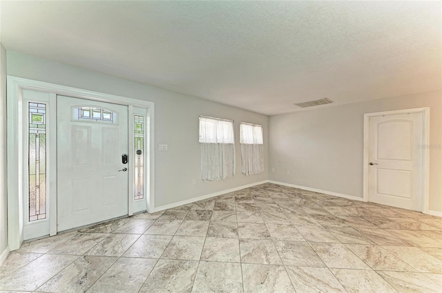 557 Reading St NW, Port Charlotte, FL 33952 - foyer featuring healthy amount of natural light and a textured ceiling