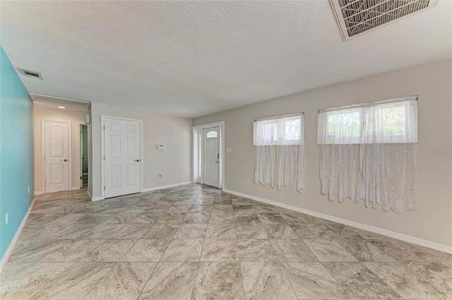 557 Reading St NW, Port Charlotte, FL 33952 - spare room featuring baseboards and a textured ceiling