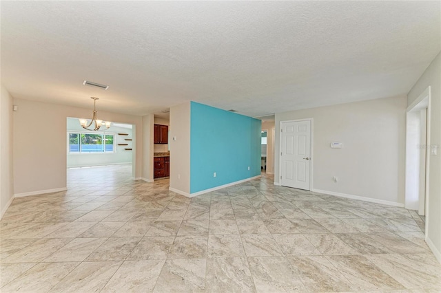 557 Reading St NW, Port Charlotte, FL 33952 - unfurnished room featuring a chandelier and a textured ceiling