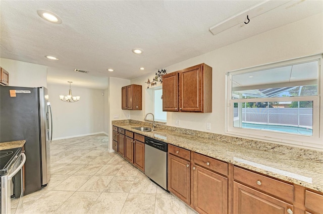 557 Reading St NW, Port Charlotte, FL 33952 - kitchen featuring stainless steel appliances, a chandelier, recessed lighting, brown cabinets, and light stone countertops