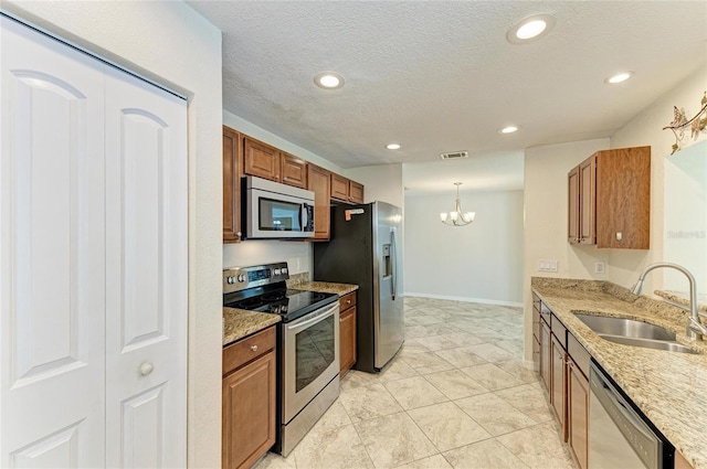 557 Reading St NW, Port Charlotte, FL 33952 - kitchen featuring stainless steel appliances, a chandelier, brown cabinetry, recessed lighting, and a textured ceiling