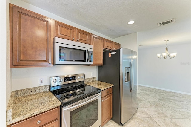 557 Reading St NW, Port Charlotte, FL 33952 - kitchen with stainless steel appliances, a chandelier, brown cabinets, recessed lighting, and a textured ceiling