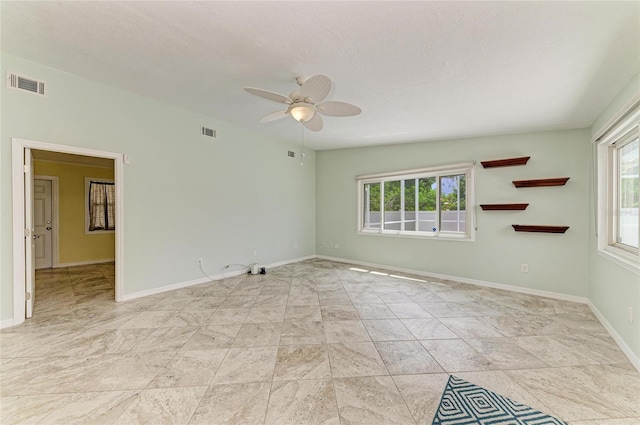 557 Reading St NW, Port Charlotte, FL 33952 - spare room featuring plenty of natural light, ceiling fan, and a textured ceiling