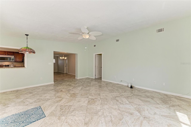 557 Reading St NW, Port Charlotte, FL 33952 - unfurnished room featuring ceiling fan and a chandelier
