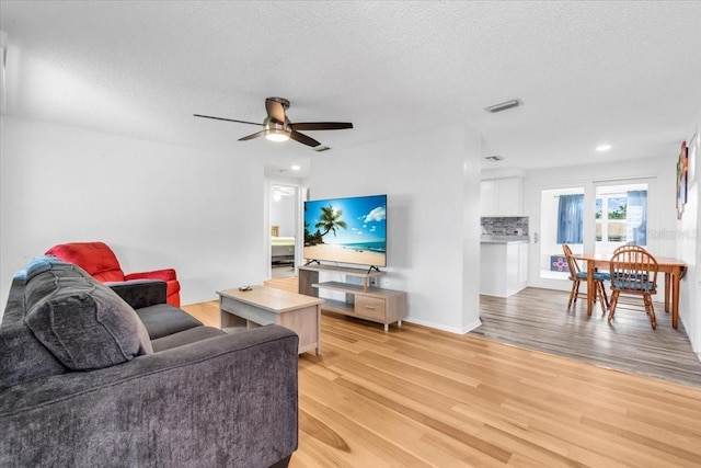 5401 Mac Arthur Ave, New Port Richey, FL 34652 - living room featuring light wood-style floors, a textured ceiling, a ceiling fan, and recessed lighting
