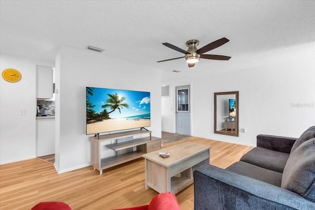 5401 Mac Arthur Ave, New Port Richey, FL 34652 - living area featuring light wood finished floors, a ceiling fan, and a textured ceiling