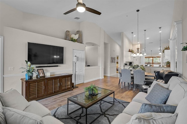 5240 Hyland Hills Ave Unit 1425, Sarasota, FL 34241 - living area with a ceiling fan, high vaulted ceiling, light wood-style flooring, and a chandelier