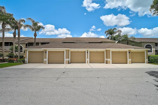 5240 Hyland Hills Ave Unit 1425, Sarasota, FL 34241 - view of front of home featuring community garages, stucco siding, and a shingled roof