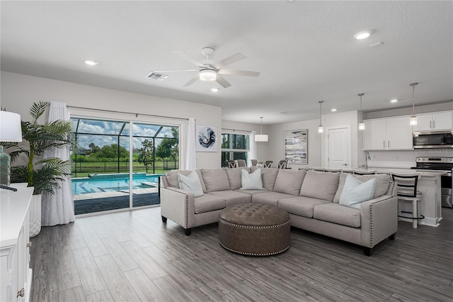 9144 Royal River Cir, Parrish, FL 34219 - living room with ceiling fan, dark wood-style flooring, recessed lighting, and a sunroom