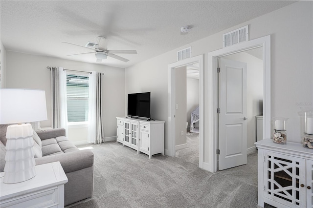 9144 Royal River Cir, Parrish, FL 34219 - living area with a ceiling fan, light carpet, and a textured ceiling