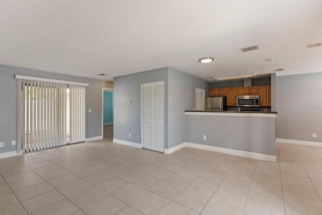 7298 Ulmerton Rd Unit 202, Largo, FL 33771 - unfurnished living room with a textured ceiling and light tile patterned floors