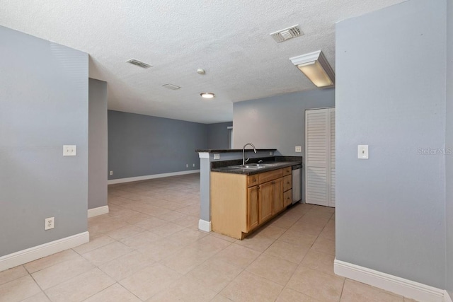 7298 Ulmerton Rd Unit 202, Largo, FL 33771 - kitchen featuring a peninsula, dark countertops, light tile patterned flooring, a textured ceiling, and dishwasher
