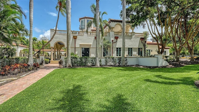 4423 Bay Shore Rd, Sarasota, FL 34234 - rear view of house featuring stucco siding, a yard, and a tile roof