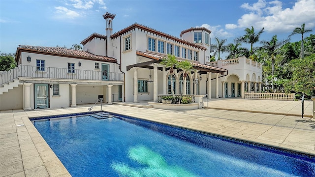 4423 Bay Shore Rd, Sarasota, FL 34234 - back of house featuring a patio, stucco siding, a tiled roof, stairs, and an outdoor pool
