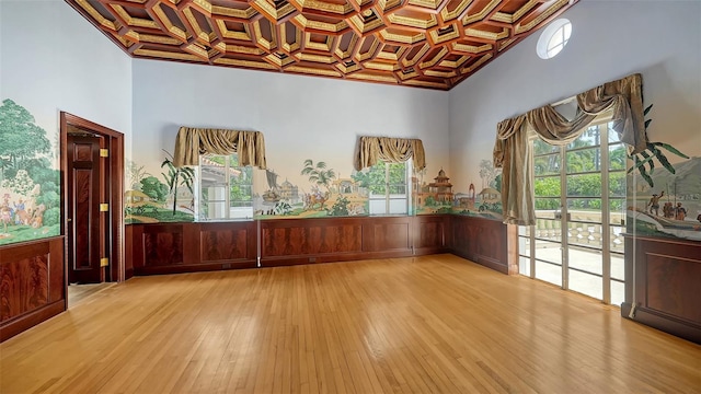 4423 Bay Shore Rd, Sarasota, FL 34234 - unfurnished room featuring coffered ceiling, light wood-type flooring, wainscoting, and a towering ceiling