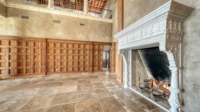 4423 Bay Shore Rd, Sarasota, FL 34234 - miscellaneous room featuring a high ceiling, stone tile floors, a warm lit fireplace, and inlaid floor details