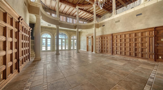 4423 Bay Shore Rd, Sarasota, FL 34234 - misc room featuring a towering ceiling, decorative columns, stone tile flooring, and a wooden ceiling with exposed beams