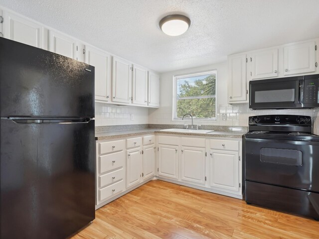 2423 Flamingo Blvd Unit K29, Bradenton, FL 34207 - kitchen featuring black appliances, tasteful backsplash, white cabinetry, a textured ceiling, and light wood-style flooring