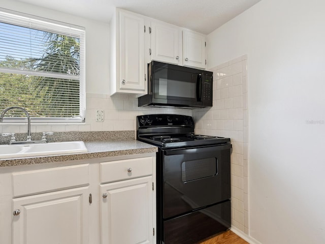 2423 Flamingo Blvd Unit K29, Bradenton, FL 34207 - kitchen featuring black appliances, white cabinets, light countertops, and decorative backsplash