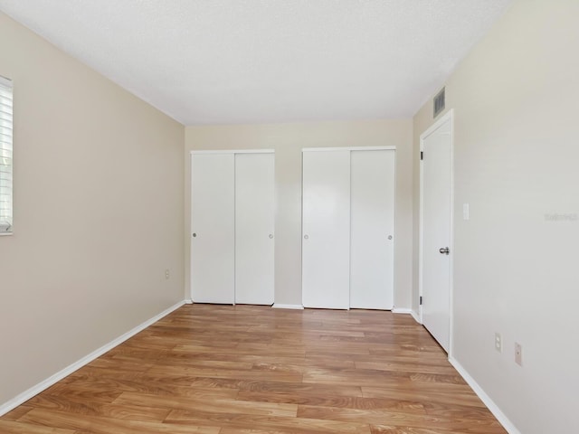 2423 Flamingo Blvd Unit K29, Bradenton, FL 34207 - unfurnished bedroom featuring multiple closets and light wood finished floors