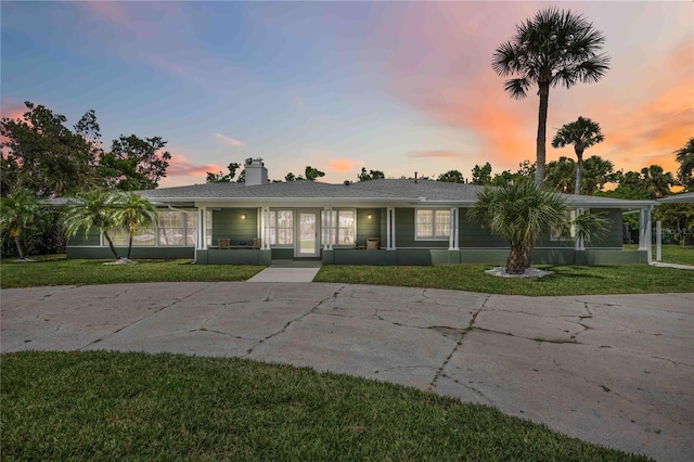 311 Island Cir, Sarasota, FL 34242 - ranch-style house featuring a front yard, covered porch, and a chimney