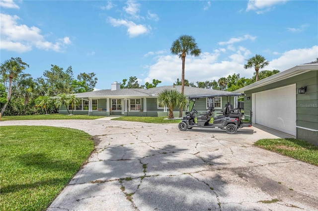 311 Island Cir, Sarasota, FL 34242 - view of front of property featuring curved driveway, a front lawn, a garage, and a chimney