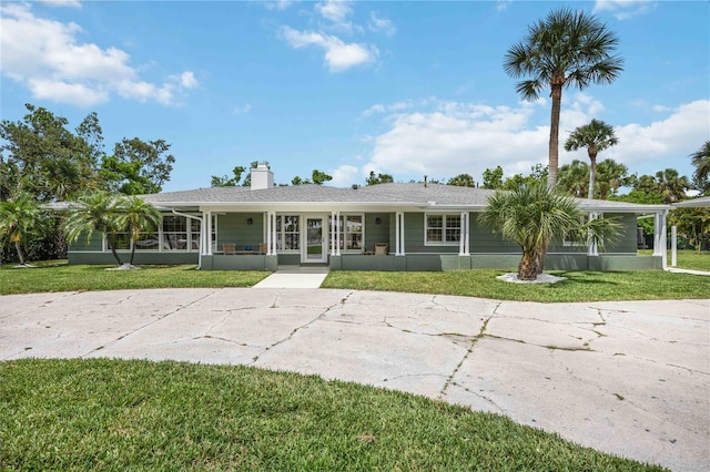 311 Island Cir, Sarasota, FL 34242 - view of front of property featuring a front yard, a chimney, and a sunroom