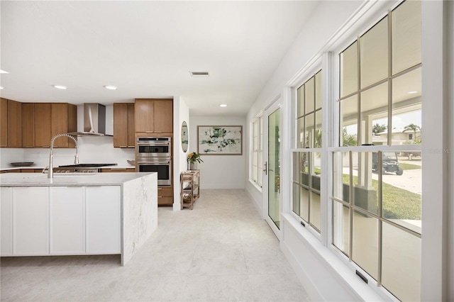 311 Island Cir, Sarasota, FL 34242 - kitchen featuring wall chimney exhaust hood, brown cabinets, light countertops, stainless steel double oven, and recessed lighting