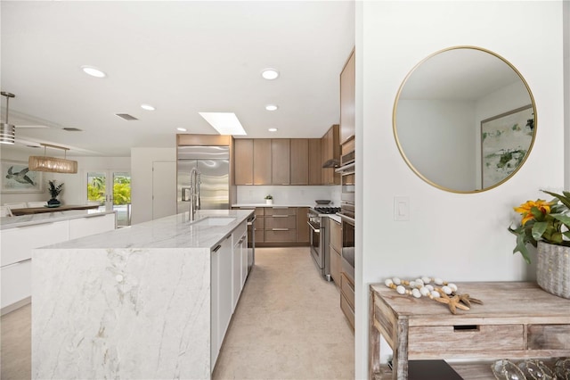 311 Island Cir, Sarasota, FL 34242 - kitchen featuring high end appliances, a center island with sink, modern cabinets, recessed lighting, and light stone counters