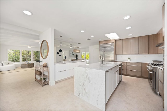 311 Island Cir, Sarasota, FL 34242 - kitchen with high end appliances, modern cabinets, an island with sink, recessed lighting, and plenty of natural light